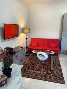 a living room with a red couch and a rug at Mini Red Hub - Design Apartment in SantʼAgapito