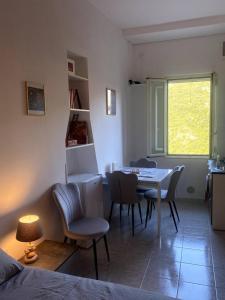 un soggiorno con tavolo, sedie e finestra di Mini Red Hub - Design Apartment a SantʼAgapito