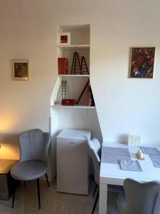 a room with a white table and chairs and a table and a shelf at Mini Red Hub - Design Apartment in SantʼAgapito