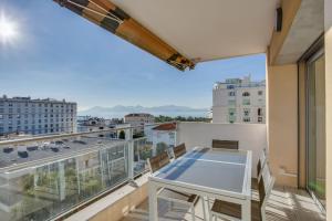 een balkon met een tafel en uitzicht op de stad bij Appartement Alexandre 3 rooms bright apartment in Cannes in Cannes