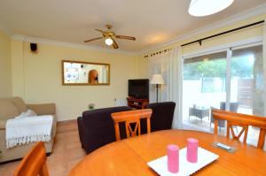 a dining room and living room with a table and chairs at Bonito chalet con piscina cerca del mar in Can Pastilla