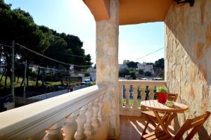 uma varanda de uma casa com uma mesa e cadeiras em Bonito chalet con piscina cerca del mar em Can Pastilla