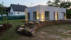 una casa blanca con un puente de piedra en un patio en Grejdy L&V, en Žďár nad Sázavou