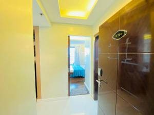 a bathroom with a door and a mirror and a room at Cebu City Suites Ramos Tower by P&J in Cebu City +77 photos