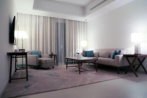 Address Resort Apartments Fujairah - 2 bedroom apartment في الفجيرة: غرفة معيشة مع أريكة وطاولة