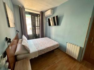 Habitación pequeña con cama y ventana en CH Casillas, en Madrid
