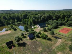 an aerial view of a farm with a house and a pond at Forest springs. Family vacation tennis beach sauna in GratiÅ¡kÄ—s