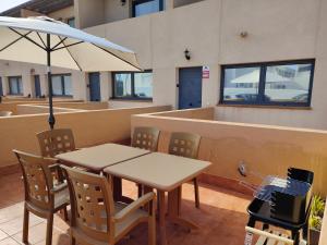 une table et des chaises avec un parasol dans un bâtiment dans l'établissement Casa Paradise, à El Cotillo
