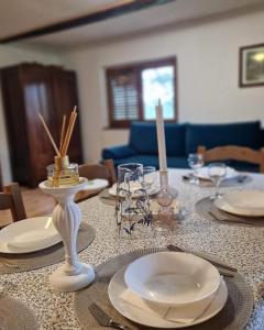 - une table à manger avec des assiettes et des bougies dans l'établissement Wooden house Mali Vrh, à Kamanje