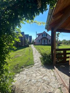 een pad naar een huis met een huis op de achtergrond bij Family Mountain Cottage in Cîrţişoara
