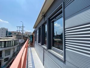 einen Balkon mit einem Fenster auf der Seite eines Gebäudes in der Unterkunft Hongdae, Private Guest House in Seoul