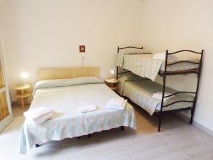 ミラノ・マリッティマにあるHotel Esedraのベッドルーム1室(ベッド2台、二段ベッド1組付)