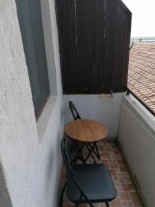 Hanul Hora Romaneasca- camere de inchiriat في إيفوري سود: طاولة صغيرة و كرسيين على شرفة