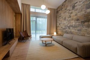 sala de estar con sofá y pared de piedra en TALBERG SK - Garage parking - Quiet place - Brand new apartments - Tále, en Tale