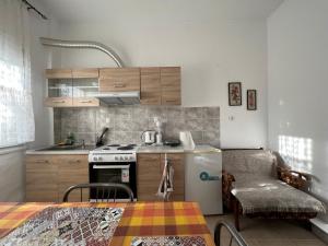 una cucina con frigorifero, piano cottura e tavolo di Suburban Oasis a Alexandroupoli