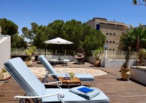 - une terrasse avec 2 chaises longues et un parasol dans l'établissement The View Penthouse Apartment, à Jérusalem