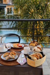 a table with plates of food and baskets of bread at Good Life Resort in La Falda