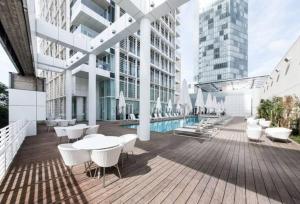 a building with a pool and tables and chairs at Exclusive 2BR Meier Tower W/Parking - Rothschild in Tel Aviv