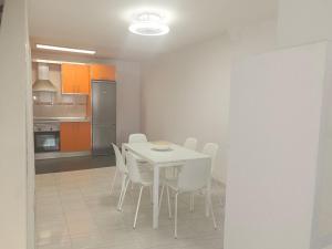 a kitchen with a white table and white chairs at Jaral Home in Puerto de Santiago