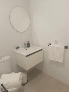 a white bathroom with a sink and a mirror at Jaral Home in Puerto de Santiago