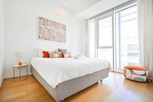 Dormitorio blanco con cama y ventana grande en Exclusive 2BR Meier Tower W/Parking - Rothschild en Tel Aviv