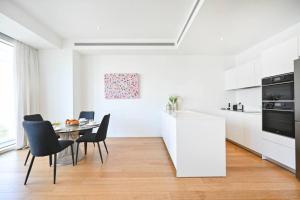 a white kitchen with a table and chairs at Exclusive 2BR Meier Tower W/Parking - Rothschild in Tel Aviv