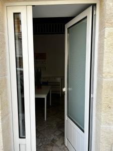 Une porte ouverte s'ouvre sur une terrasse avec une table. dans l'établissement La casa di Ginevra, à Polignano a Mare