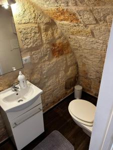 La salle de bains est pourvue d'un lavabo blanc et de toilettes. dans l'établissement La casa di Ginevra, à Polignano a Mare