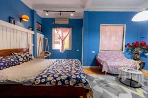 um quarto com paredes azuis, uma cama e uma mesa em Hoankiem House em Hanói