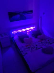 um quarto com uma cama numa luz roxa em Chez Riz em Arles