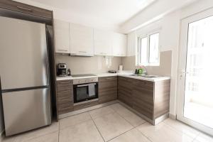 a kitchen with white cabinets and a stainless steel refrigerator at Cozy 2-bedroom Apartment in Piraeus (ERM_E9) in Piraeus