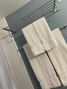 three towels are hanging on a rack in a bathroom at ~Four-star serviced apartment in Honolulu