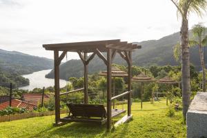 un banco de parque con cenador en el césped en Quinta Flor de Lis, Gerês, en Vieira do Minho