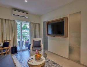 a living room with a tv and a couch and a table at Royal Orchid Beach Resort & Spa, Utorda Beach Goa in Utorda