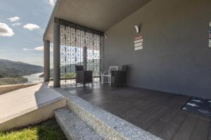 a house with a balcony with a view of a river at Quinta Flor de Lis, Gerês in Vieira do Minho
