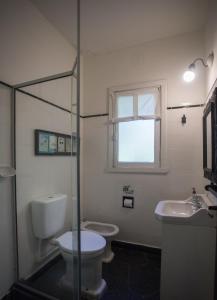 baño con 2 aseos, lavamanos y ventana en Green House Bariloche en San Carlos de Bariloche