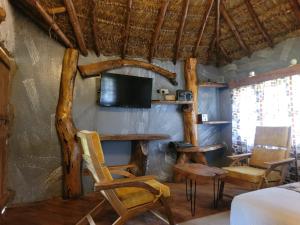 Pokój ze stołem i krzesłami oraz telewizorem w obiekcie Podocarpus cottages w mieście Naro Moru