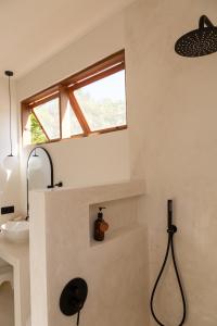 a bathroom with a shower and a sink and a window at Villa Luna - Gili Air in Gili Air