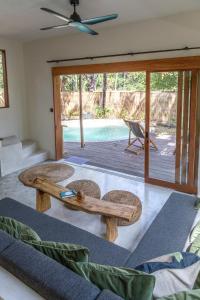 a living room with a table and chairs and a pool at Villa Luna - Gili Air in Gili Air