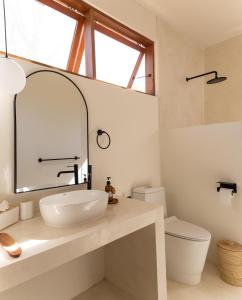 y baño con lavabo blanco y espejo. en Villa Luna - Gili Air, en Gili Air