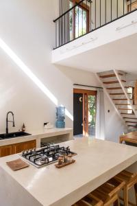 een keuken met witte werkbladen en een trap bij Villa Luna - Gili Air in Gili Air