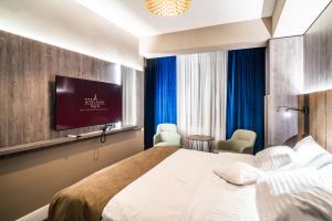 une chambre d'hôtel avec un lit et une télévision à écran plat dans l'établissement Hotel Anna, à Târgu Jiu