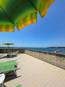 un patio con tavoli, ombrelloni e oceano di Hotel La Marinella a Castiglioncello