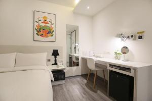 a white room with a bed and a desk and a sink at CityInn Hotel Plus - Ximending Branch in Taipei