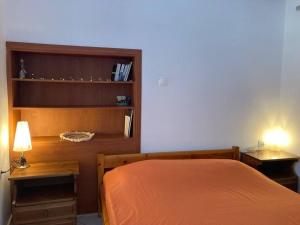 a bedroom with a bed and two tables and a shelf at Walk on the beach in seconds - Studio with Apollon beach view balcony in Apollon