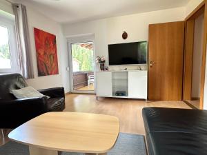 un soggiorno con tavolo e TV a schermo piatto di Haus Sonnenspitze - Fam. Nessler a Biberwier