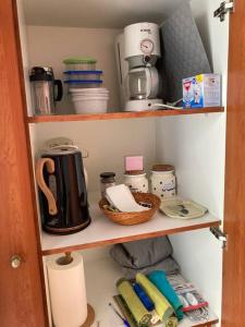 a cupboard with a coffee maker and other kitchen items at Walk on the beach in seconds - Studio with Apollon beach view balcony in Apollon