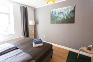 a bedroom with a bed and a painting on the wall at FULL HOUSE Studios - The Forest Apartment - Nespresso inkl in Halle an der Saale