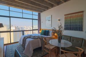 - une chambre avec un lit et une table avec vue dans l'établissement Vossa Bossa Copan, à São Paulo