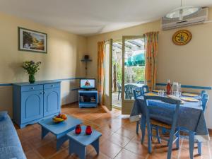 un salon avec une table bleue et des chaises dans l'établissement Lagrange Vacances Les Mazets de Gaujac, à Gaujac